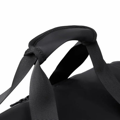 Alça  da mala de academia masculina em couro sintético preto, mostrando o compartimento para tênis.
