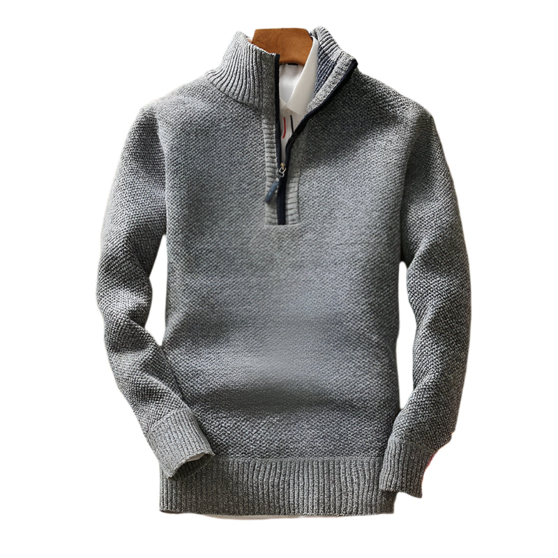 "Detalhe do suéter de malha usado com o zíper fechado, formando uma elegante gola alta que protege do frio."